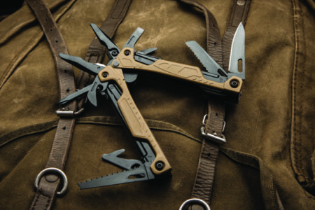 Modern multitool with many tools. A portable multitasking tool on a vintage canvas backpack.